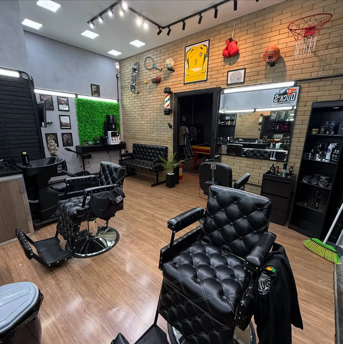 Ambiente da Duck's Barber com cadeiras de couro e decoração esportiva